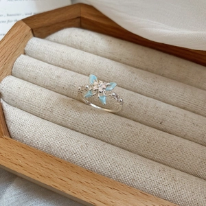 Vue détaillée d'une bague papillon en argent avec émail bleu et perles sur bois