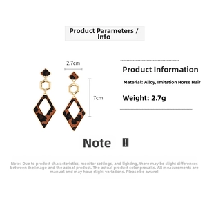 Detailed view of geometric leopard print earrings with gold frames and faux horsehair texture