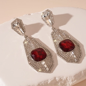 Detailed macro of vintage geometric earrings with large red gemstone and zircon accents