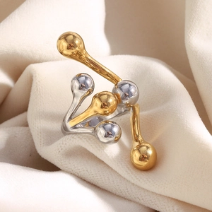 Detailed view of bicolor gold and silver spherical ring on white fabric background