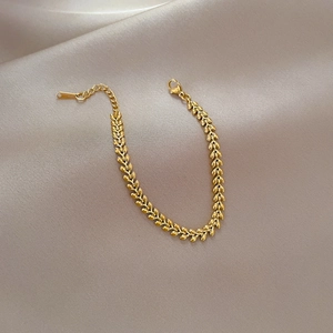 Macro shot of gold-plated wheat link chain bracelet with adjustable lobster clasp