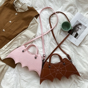 Detail view of pink and brown bat wing PU bags with spider web stitching and silver hardware