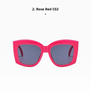 Detail of rose red wide-frame sunglasses with dark lenses and bold temple design
