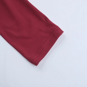 Détail des poignets d'une robe en maille bordeaux avec des ourlets à double couture