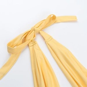 Detail der leuchtend gelben elastischen Träger und des Knotens eines figurbetonten Sommer-Vests