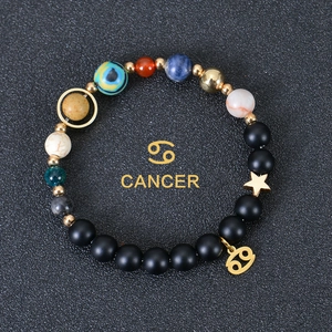 Detail of beaded solar system bracelet with Cancer zodiac sign and golden star charm