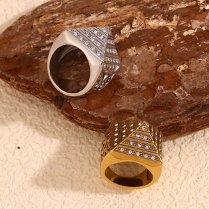 Macro detail of men's pyramid rings in gold and silver with inlaid stones on wood