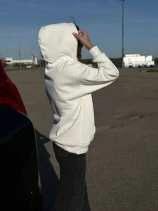 Πίσω όψη ενός casual λευκού oversized φούτερ με κουκούλα και ρυθμιζόμενα κορδόνια