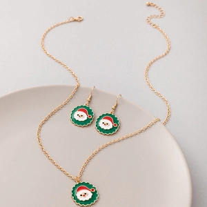 Festive Santa Claus enamel jewelry set including gold necklace and earrings on ceramic tray