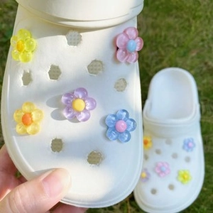 Colorful 3D resin flower charms for clog shoes decoration on green grass background