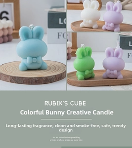 Detail of four Morandi colored bunny candles with bows on a wooden tray decor