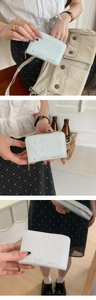 Macro shot of light blue PU leather wallet with cute cat embossing and gold zipper detail