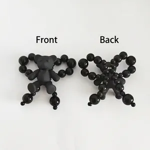 Front and back detail of matte black bear accessory with shiny bead trim decoration