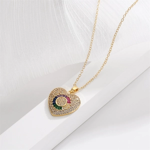 Golden heart necklace with rainbow cubic zirconia stones on white textured fabric