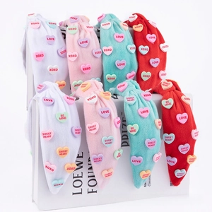 Detail of coral fleece headbands with colorful heart buttons and romantic text