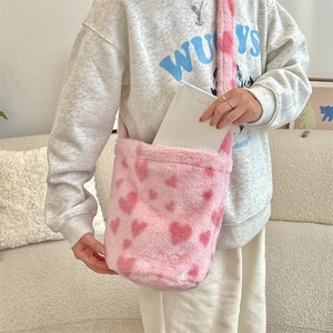 Pink plush crossbody bucket bag with heart patterns showing spacious interior storage