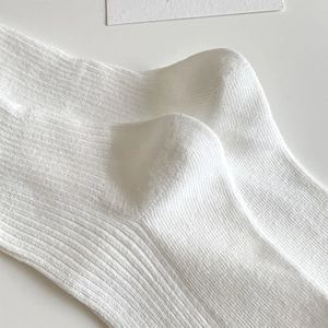 Close-up of white JK Lolita socks with ribbed knit pattern and cute bow detailing