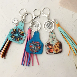 Detail of Western bull skull and sunflower leather keychains with suede tassels