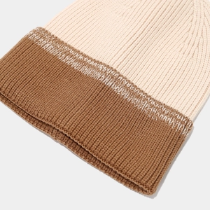 Macro detail of the color-block knitted hat featuring thick vertical striped textures