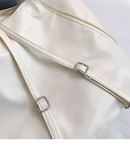 Dettaglio della tracolla in pelle bianco sporco con due fibbie quadrate in metallo argento