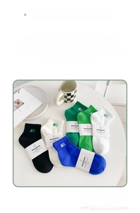 Detailed view of combed cotton socks with NA letter embroidery in various colors