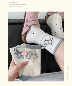 Detail of cute knitted cotton mid-calf socks with animal patterns and bow accents
