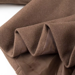 Vue détaillée de la texture du tissu en laine marron et de sa doublure intérieure