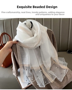 Detailed shot of elegant white sheer shawl with exquisite faux pearl beadwork and trim