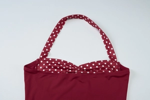 Detail view of burgundy halter neck top with white polka dots and elastic straps