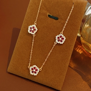 Dettaglio della collana placcata oro 18K con eleganti ciondoli a fiore rossi e bianchi