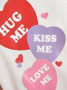 Detail of white mesh fabric with colorful heart prints and Hug Me slogans for pet shirts