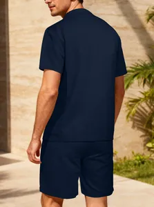 Vista posteriore del set polo e pantaloncini in maglia a nido d'ape blu navy per uomo al sole