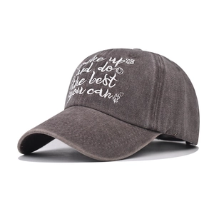 Detailed embroidery on a washed dark grey baseball cap with motivational text