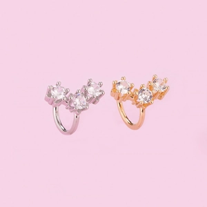 Detail view of silver and rose gold non-piercing ear cuffs with three round zircons
