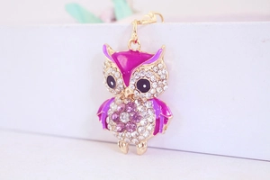 Macro view of purple enamel owl keychain with sparkling rhinestones and golden alloy detail