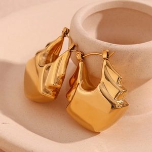 Macro shot of 18K gold plated triple layered hollow fan earrings on ceramic base