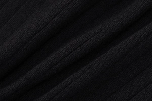 Gros plan sur la texture en maille côtelée noire d'un gilet à manches longues chic