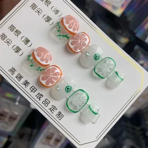 Détail d'ongles 3D avec reliefs de fruits orange et citron sur base gelée transparente