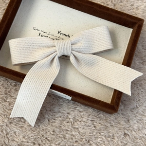 Detailed macro view of the cream knit bow hair clip with textured ribbed fabric