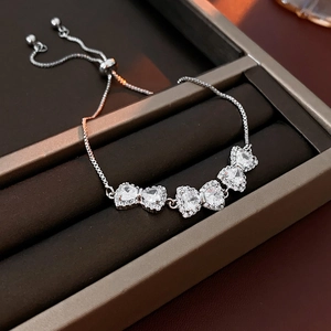 Dettaglio del bracciale a fiocco argento con motivi a cuore e chiusura a scorrimento