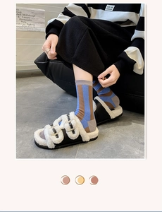 Detail of plush faux fur lining on black buckle slide sandals with striped crew socks