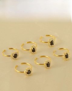 Detail of 18k gold stainless steel rings with black stones in various geometric shapes