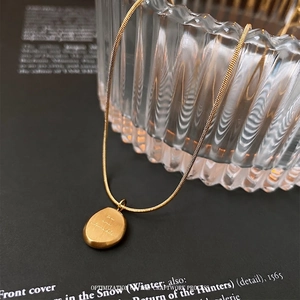 Vintage gold titanium necklace with engraved pebble pendant on snake chain