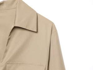 Primer plano detallado de las costuras del hombro y la textura de sarga del vestido caqui