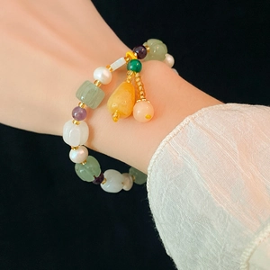 Detailed shot of multi-color gemstone beads and white pearls on a beaded bracelet