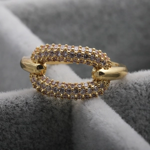 Makro-Detail des goldenen geometrischen Rings mit lila Zirkon-Mikropavee auf Samt