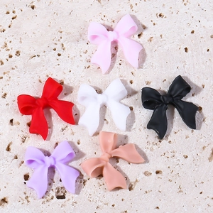 Set of 6 colorful resin 3D bow nail art charms in matte finish on stone texture
