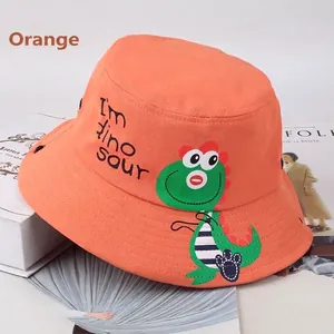 Dettaglio cappello a secchiello arancione in cotone per bambini con stampa dinosauro e foro