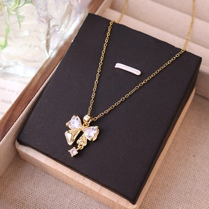 Élégant collier nœud doré avec pendentifs en zircon blanc sur support à bijoux