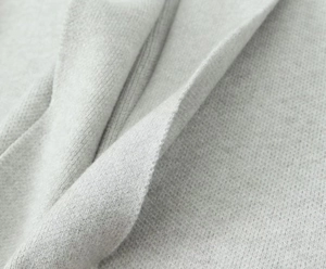 Close-up of premium light gray knit fabric showing soft texture and fine ribbing detail